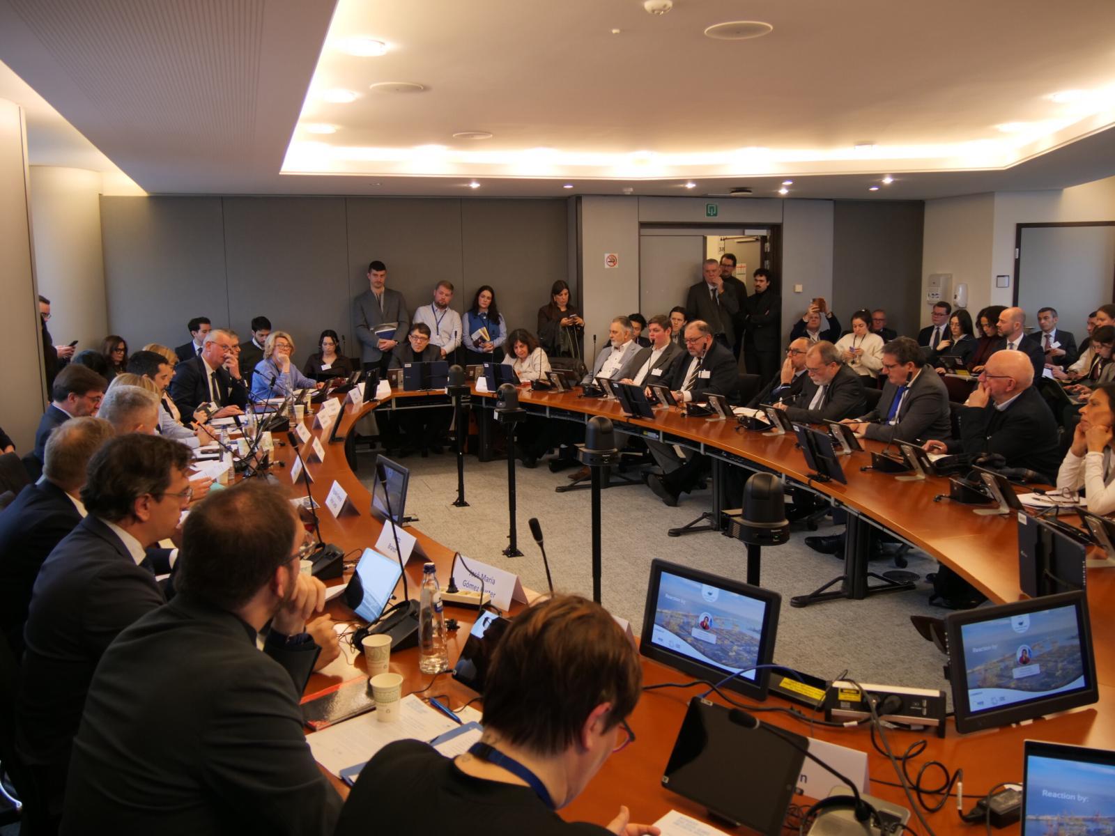 Representantes regionales, autoridades portuarias y eurodiputados reunidos alrededor de una mesa en una sala del Parlamento Europeo en Bruselas