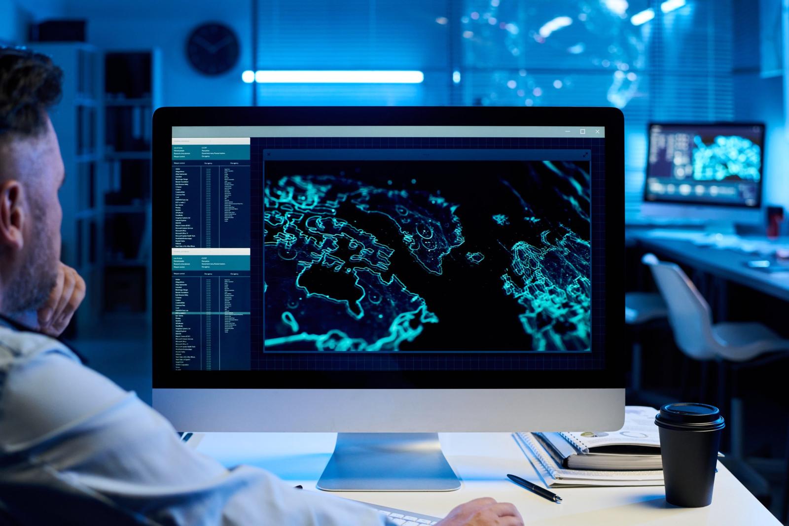 Person at a computer showing a digital map with coastlines highlighted in blue