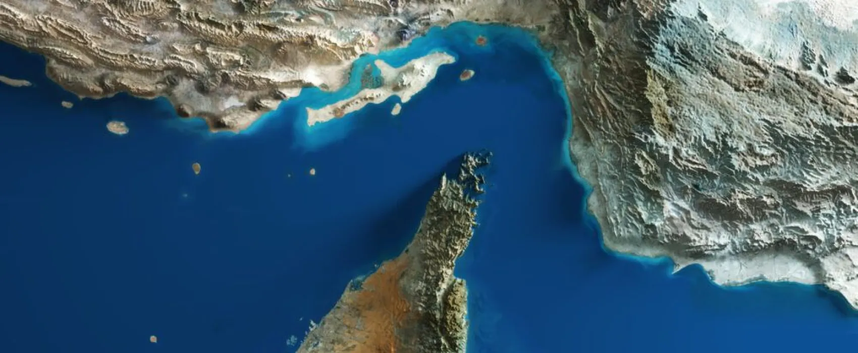 Aerial view of the Strait of Hormuz with topographic relief, between the Iranian coast to the north and the United Arab Emirates and Oman to the south.