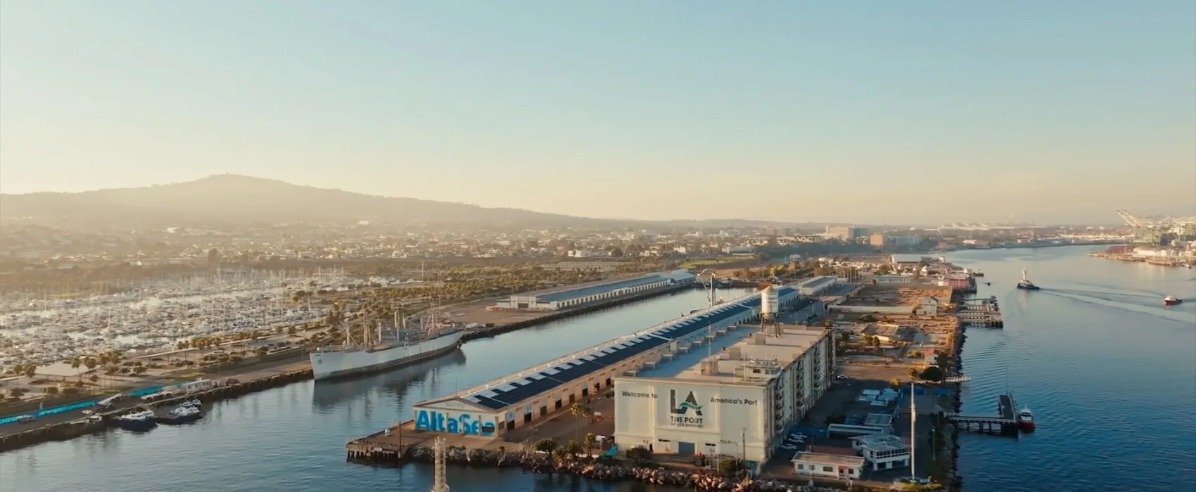 Vista aérea del campus de innovación AltaSea, en el puerto de Los Ángeles, con sus naves portuarias y embarcaderos junto al mar.