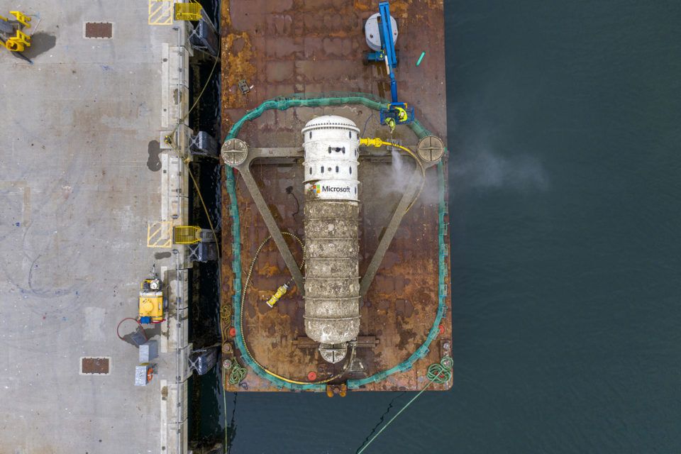 Aerial view of Microsoft's Project Natick submarine module during its recovery in the Orkney Islands, Scotland, showing the white cylinder with 864 servers inside (Microsoft).