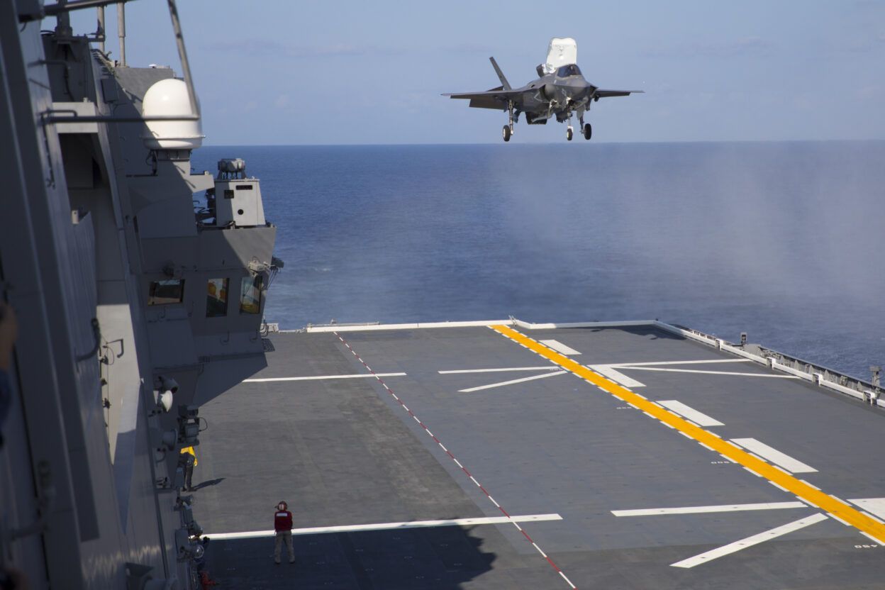An F-35B conducts a vertical landing on the deck of the JS Izumo, the Japan Maritime Self-Defense Force helicopter carrier being adapted to operate these fifth-generation fighter jets (JMSDF CC).